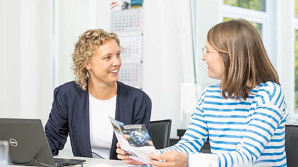 two woman talking sitting at a table