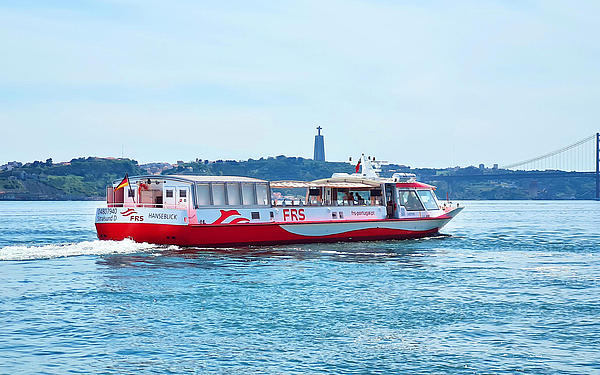 Vessel cruising on the Tagus river, Cristo Rei and the Ponte 25 de Abril in the background.