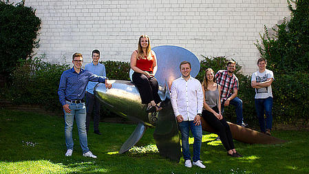 Apprentices standing around a propeller.