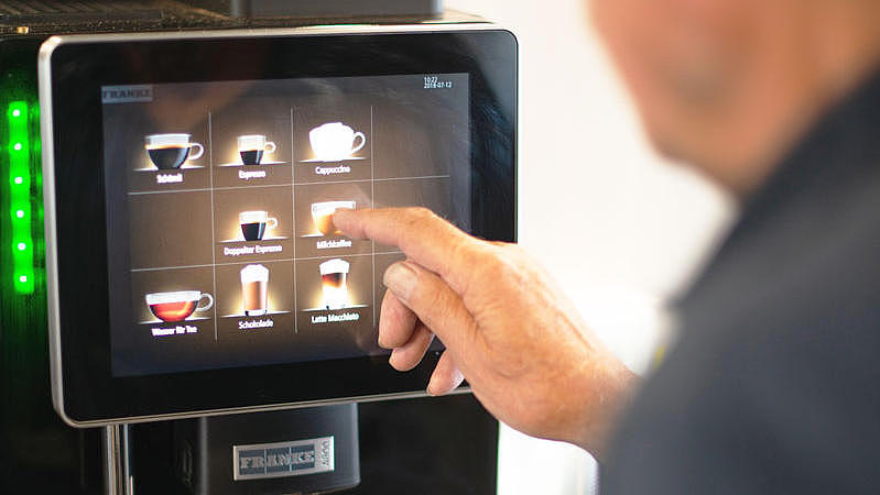 A man, who uses a coffee machine.