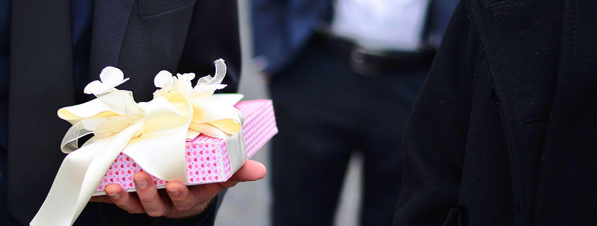 A person, who is holding a gift in his hands.