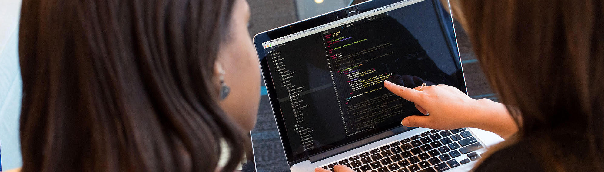 Two women looking at a laptop screen.
