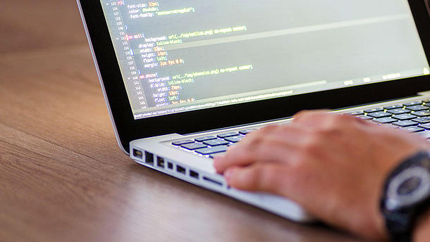 Person programming on a laptop computer.