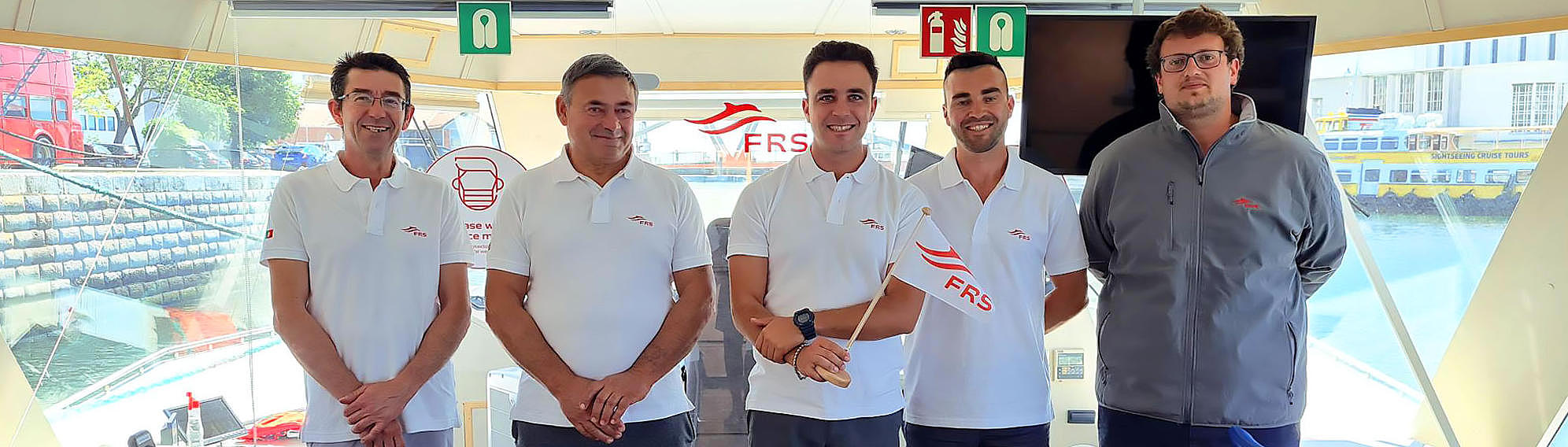 FRS employees standing on board with a FRS Flag