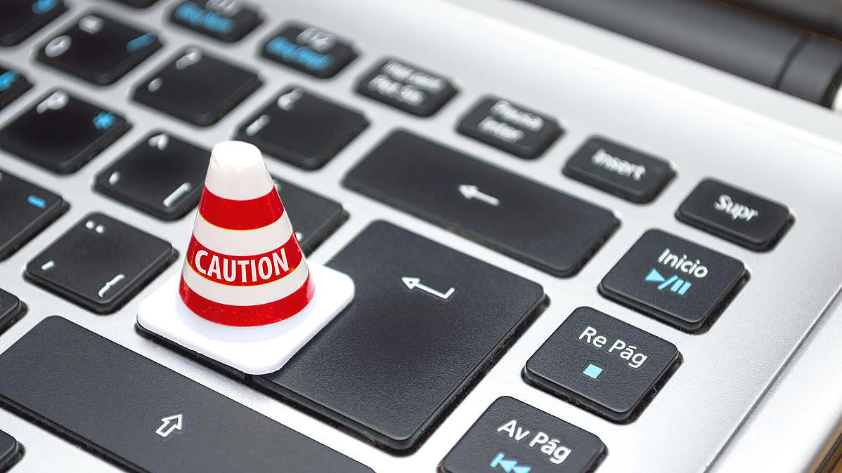 A notebook keyboard covered with ''caution'' pylon.