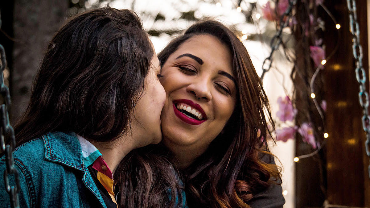  two women, who are kissing each other.
