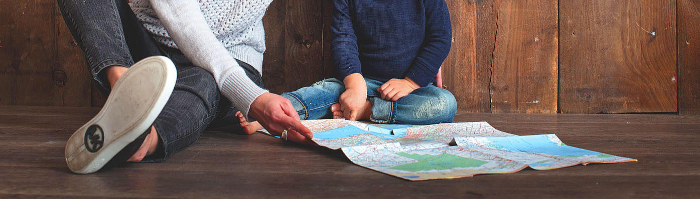 An adult and a baby, who are looking at a map.
